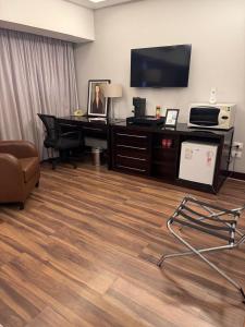 Cette chambre comprend un bureau avec un ordinateur et une télévision. dans l'établissement WB Berrini São Paulo, à Água Boa