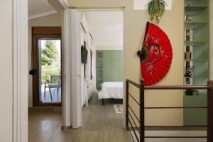 a hallway with a red umbrella on the wall at Frida & Rosa by halu! - Villas in Kriopigi in Kriopigi