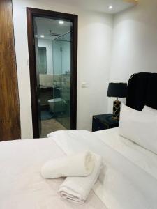un asciugamano bianco seduto sopra un letto di Gold Crest Prestige Premium Duplex Modern Serviced Apartments DHA 4 Lahore - LMY Residency a Lahore Altre 38 foto