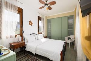 a bedroom with a white bed and a green wall at Frida & Rosa by halu! - Villas in Kriopigi in Kriopigi +29 photos