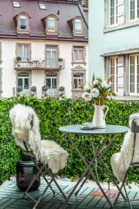 einen Tisch und zwei Stühle mit einer Blumenvase in der Unterkunft Boutiqueluxury Balcony Ac Downtown in Zürich