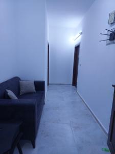 a living room with a couch and a white wall at Cozy Home 3 in Amman