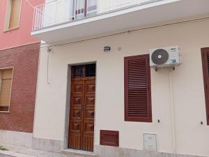 a white building with a door and a window at Casa vacanze terrAmare in Avola