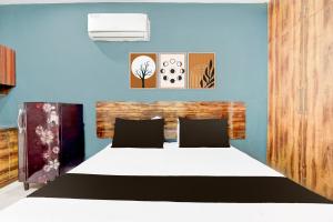 sypialnia z łóżkiem i niebieską ścianą w obiekcie Hotel O Arpit Residency w mieście Gurgaon +21 zdjęć