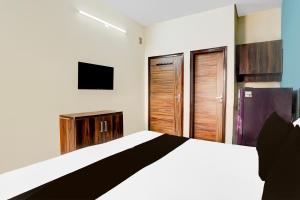 sypialnia z białym łóżkiem i telewizorem w obiekcie Hotel O Arpit Residency w mieście Gurgaon