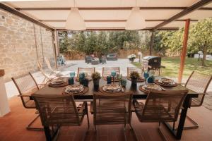 a table on a patio with chairs and a grill at DONNA LAURA - Holiday Home in Arezzo
