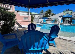 a group of blue chairs sitting next to a swimming pool at Sun Caraibes in Orient Bay