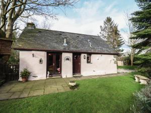 une petite maison blanche avec une cour gazonnée dans l'établissement Hafoty Boeth Cottage, à Corwen