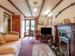 un salon avec un canapé et une cheminée dans l'établissement Hafoty Boeth Cottage, à Corwen