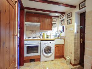 une cuisine avec une machine à laver et un lave-linge dans l'établissement Hafoty Boeth Cottage, à Corwen