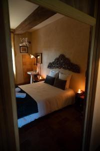 a bedroom with a large bed in a room at Les Jardins des Soussilanges in Céron