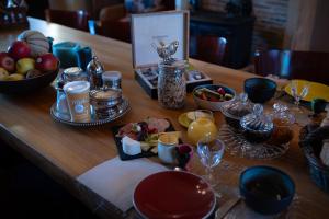 a wooden table topped with plates and bowls of food at Les Jardins des Soussilanges in Céron
