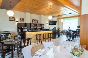 a restaurant with tables and chairs and a bar at Pension Resort Dreistern in Göda