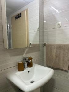 a bathroom with a white sink and a mirror at Home apartment in Skopje +10 photos