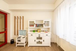 a room with a white cabinet with a toy stove at Pension Resort Dreistern in Göda