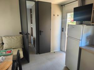 a small kitchen with a refrigerator and a table and a table and a tablektop at Camping la Croix du Sud in Saint-Tropez