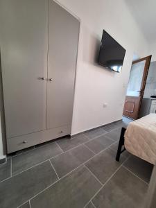 a bedroom with a bed and a tv on the wall at Aegean Traditional Suite Ιn Glinado in Glinado Naxos