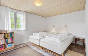 a bedroom with a bed and a book shelf at Lærkereden in Allinge +15 photos