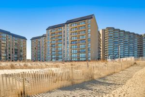 dos edificios altos en la playa al lado de una valla en Sea Colony --- 703 Farragut House Rd, en Bethany Beach