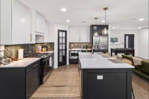 a kitchen with black and white appliances and a living room at Luxury Oasis 4B 2B Jacuzzi Pet Friendly in Plano +17 photos