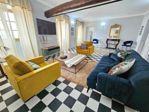 a living room with a blue couch and yellow chairs at Magnifique villa avec piscine- hauteurs de Bastia in Bastia