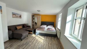 a small bedroom with a bed and a couch at Fewo Arthur am Elbtal in Meißen