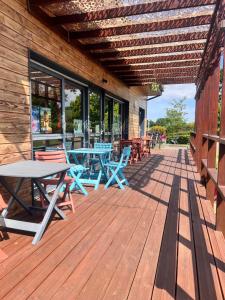 a wooden deck with tables and chairs on a building at Camping La Tourelle in Plémy