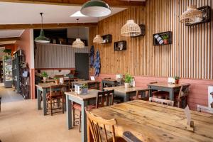 un restaurant avec des tables et des chaises en bois dans une salle dans l'établissement River Cottage HQ, à Musbury