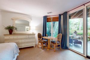 a bedroom with a table and chairs and a mirror at Ameila Island Plantation condo with beach access, private patio and pool. in Fernandina Beach