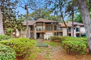 an exterior view of a large house with trees at Ameila Island Plantation condo with beach access, private patio and pool. in Fernandina Beach