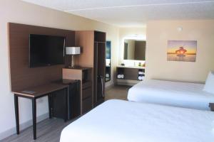 ein Hotelzimmer mit zwei Betten und einem Flachbildfernseher in der Unterkunft Angel Inn Near IMAX, a Travelodge by Wyndham in Branson
