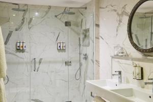 a bathroom with a shower and a sink at Harbour Hotel & Spa Christchurch in Christchurch