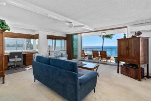 a living room with a blue couch and a view of the ocean at Big Island Kona Reef D-22 by Coldwell Banker Island Vacations in Kailua-Kona