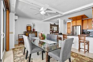 a dining room with a glass table and chairs at Big Island Kona Reef D-22 by Coldwell Banker Island Vacations in Kailua-Kona