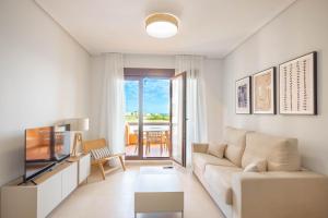 a living room with a couch and a television at Palm & Sea apartment in Los Alcázares