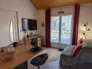 a living room with a couch and a table at Lana Cottage 3 Etoiles Jardin in Montjean