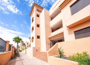 a facade of a building with stairs and palm trees at Palm & Sea apartment in Los Alcázares