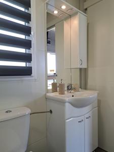 a bathroom with a sink and a toilet and a window at Small country house in Manjadvorci +39 photos