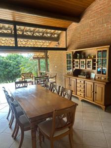 a dining room with a wooden table and chairs at Sítio Céu da Mantiqueira in Espirito Santo Do Pinhal