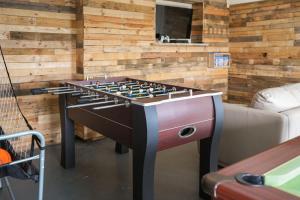 un biliardino in una stanza accanto a un divano di Beautiful Barn Conversion with Games Room a Ilfracombe