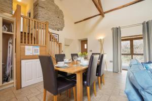 una sala da pranzo con tavolo e sedie in legno di Beautiful Barn Conversion with Games Room a Ilfracombe