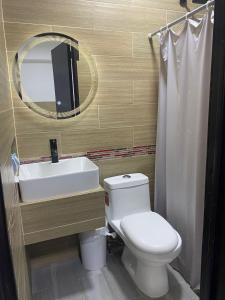 a bathroom with a toilet and a sink and a mirror at DON CELES in Paraíso +10 photos