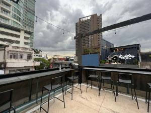 a bar with chairs on the roof of a building at Comfy Crib Hostel in Bangkok