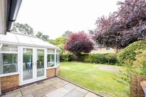 a house with a conservatory and a garden at Modern Family Home in South Manchester/Stockport in Cheadle