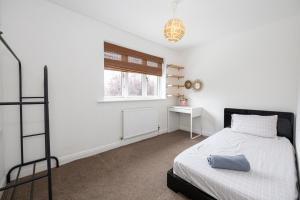 a white bedroom with a bed and a window at Modern Family Home in South Manchester/Stockport in Cheadle