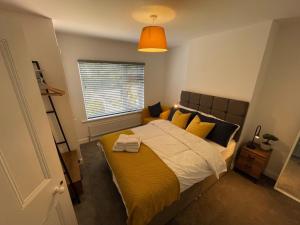 una camera da letto con un letto con cuscini gialli e neri di Cozy, Spacious 2BD House in Historic Chapelfields a Spon End