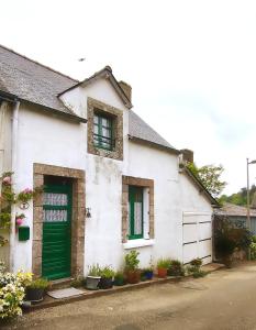 Casa blanca con puertas verdes y macetas en Les Hortensias à ST GILLES VIEUX MARCHE WIFI NETFLIX CALME, en Saint-Gilles-du-Vieux-Marché