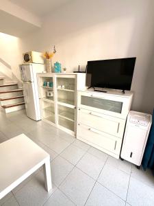 a living room with a television and a white refrigerator at Maspalomas Casa Oceano in Maspalomas