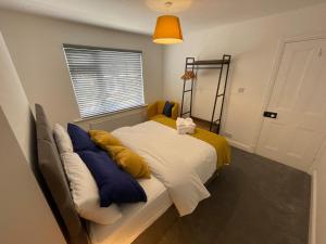 una camera da letto con un letto con cuscini gialli e blu di Cozy, Spacious 2BD House in Historic Chapelfields a Spon End