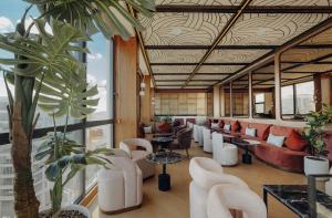 a lobby with chairs and tables and a large window at Exe Casablanca in Casablanca +50 photos